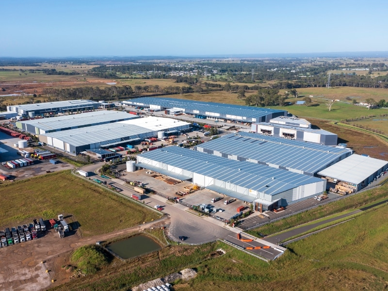 Aerial view of large industrial facility involved in Battery Recycling Project, showing warehouses, equipment, and transport access.