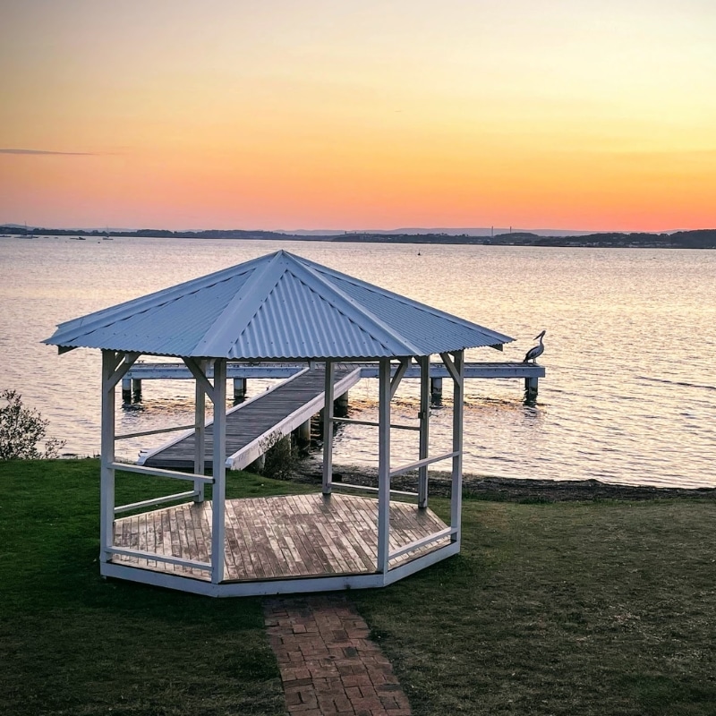 Lakeside gazebo and jetty at sunset representing community-focused town planning in Lake Macquarie.
