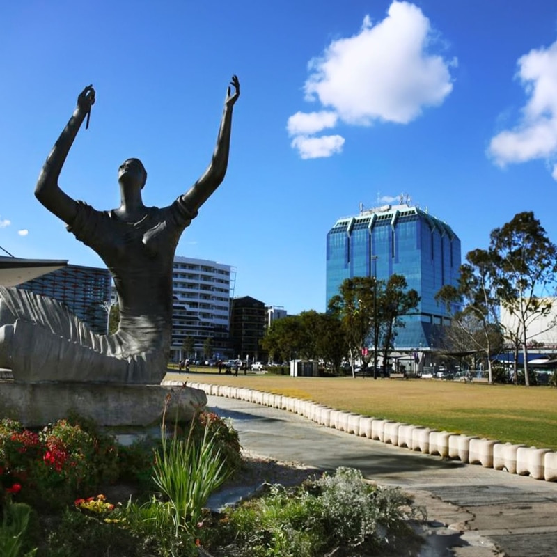 Statue and modern buildings in Canterbury-Bankstown symbolising urban development and town planning.